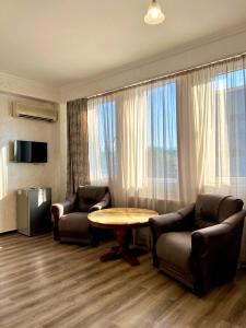 ein Wohnzimmer mit 2 Stühlen, einem Tisch und einem TV in der Unterkunft BATUMI KEY 8 in Batumi