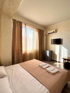 a bedroom with a large bed with two towels on it at BATUMI KEY 8 in Batumi