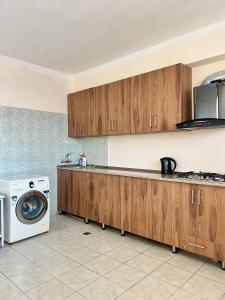 a kitchen with wooden cabinets and a washing machine at BATUMI KEY 8 in Batumi
