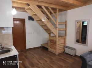 kuchnia z drewnianymi spiralnymi schodami w pokoju w obiekcie BRVNARA MILA w mieście Zaovine