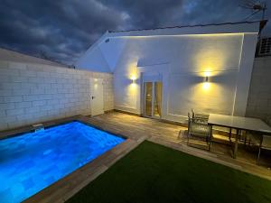 een zwembad met een tafel naast een huis bij Huellas de la Mancha in Burguillos de Toledo
