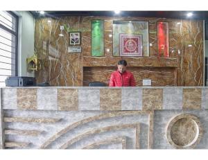 a woman standing behind a counter in a restaurant at Hotel Satkar, Pithoragarh in Pithorāgarh