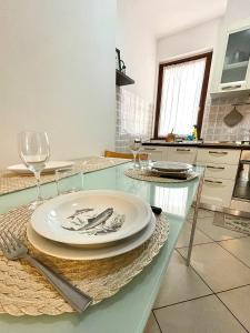 uma mesa com um prato e copos de vinho sobre ele em Sea la Vie em Alghero