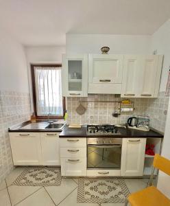 a kitchen with white cabinets and a stove top oven at Sea la Vie in Alghero