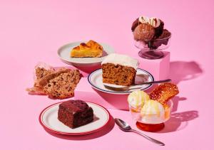 a group of desserts on plates on a pink background at Hotel Graphy Nezu in Tokyo