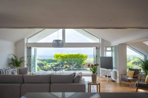Una sala de estar con un sofá y una ventana grande. en High Tide, en Milford on Sea