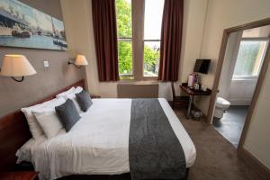 a bedroom with a large white bed with pillows at Channings Hotel by Greene King Inns in Bristol