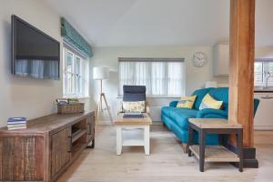 a living room with a blue couch and a tv at Butler's Barn in Newmarket