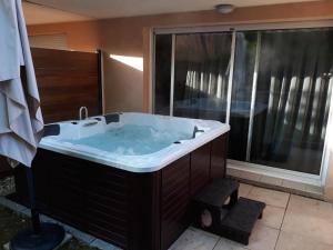 una vasca da bagno in una stanza con una grande finestra di Logis Hôtel Parenthèse, Restaurant & Spa a Chille