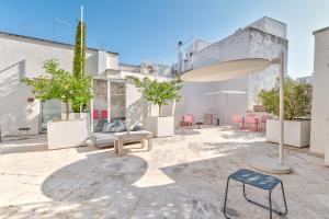 a patio with a couch and a table and chairs at Arya Nobile Dimora in Carovigno