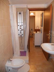 een badkamer met een douche, een toilet en een wastafel bij Alpini Apartments in Chiesa in Valmalenco