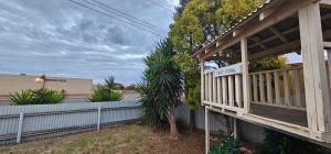 a wooden porch on a house with a fence at Spacious 5-bed house opposite IGA & Golf Course in Kalgoorlie