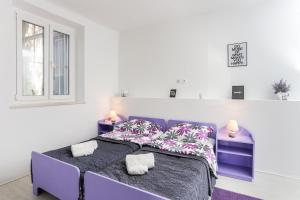 a bedroom with a purple bed and two night stands at Apartment Saulan in Dubrovnik