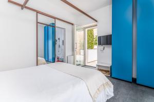 una camera con un letto bianco e una parete blu di Arya Nobile Dimora By Raro Villas a Carovigno