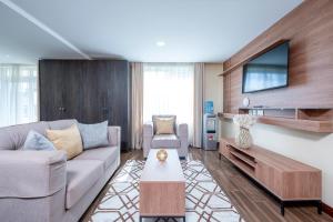 a living room with a couch and a tv at Roma Court Serviced Apartments in Nairobi