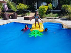 a girl on a raft in a swimming pool at Nadi Fancy Hotel in Nadi