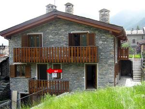 een huis met een balkon en een terras bij Alpini Apartments in Chiesa in Valmalenco