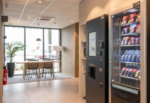 a drink refrigerator in a restaurant with a table at B&B HOTEL Saint-Geours-de-Maremne Hossegor in Saint-Geours-de-Maremne