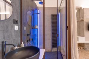 ein Bad mit einem schwarzen Waschbecken und einer Dusche in der Unterkunft Arya Nobile Dimora By Raro Villas in Carovigno