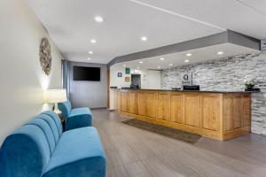 a waiting room with blue chairs and a bar at Quality Inn & Suites in Lincoln