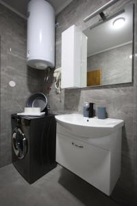 a bathroom with a sink and a washing machine at Enjoy Apartments Prilep in Prilep