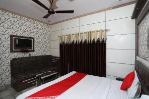 a bedroom with a bed and a flat screen tv at OYO Hotel Vanshika in Agra