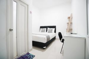 1 dormitorio con 1 cama y escritorio con silla en Griya Sawamah Syariah Mitra RedDoorz, en Yakarta
