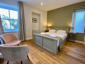 a bedroom with a bed with a desk and a chair at Riverbanc in Llangollen