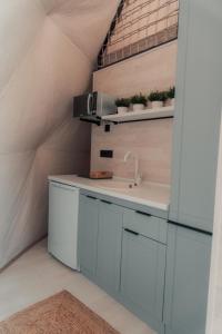 a kitchen with white cabinets and a sink at O'MIR glamping эко-отель Актау in Kyzylkum