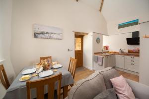 a kitchen and dining room with a table and a couch at Orchard View in Stoke Rivers