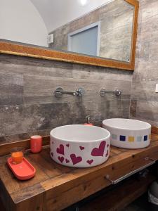 - une salle de bains avec deux lavabos sur un comptoir en bois dans l'établissement CASA DI 'NZUSU, à Carovigno