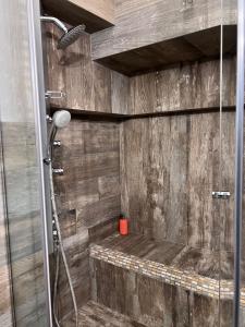 La salle de bains est pourvue d'une douche et d'un mur en bois. dans l'établissement CASA DI 'NZUSU, à Carovigno