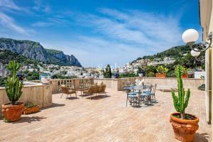 patio con mesa y sillas en el balcón en Villa 4 Colonne, Capri, en Capri