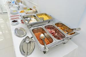 a buffet with several trays of food on a table at Mon Repos Hotel in Ayia Napa