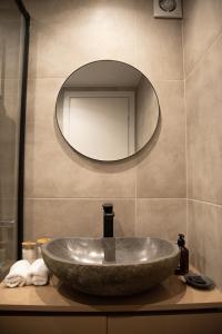 a sink in a bathroom with a mirror at Naiads Nest - The Garden Gem in Varkiza