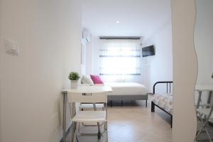 1 dormitorio pequeño con 1 cama, mesa y sillas en Republic B&B, en Bitonto