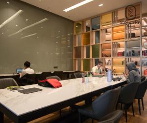 a group of people sitting around a large table in a room at AXQUISITE SUITES at KLCC in Kuala Lumpur