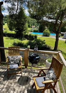 2 sillas y una parrilla en una terraza de madera en AZUR Camping Schwäbische Alb en Sonnenbühl