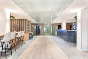 an office lobby with a bar and stools at Holiday Inn Express Paris-Canal De La Villette, an IHG Hotel in Paris