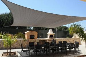 a group of tables and chairs under a white canopy at Villa Paraiso in Lagoa