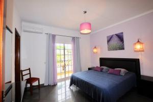 a bedroom with a bed and a large window at Villa Paraiso in Lagoa +9 photos