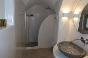 a bathroom with a sink and a shower at Lamar Cave house in Emporio Santorini