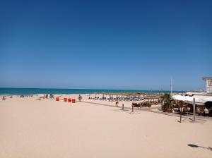 a beach with a lot of people and the ocean at Gades Natura Apartment a 450 mts Victoria beach in Cádiz
