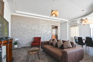 a living room with a brown couch and chairs at Millennium Penthouse with private Hot Tub Gozo in Għajnsielem