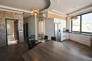 a kitchen with a large wooden table in a room at Millennium Penthouse with private Hot Tub Gozo in Għajnsielem