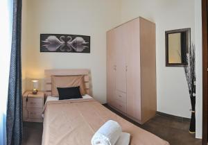 Millennium Penthouse with private Hot Tub Gozo في غاينسييليم: غرفة نوم مع سرير وخزانة