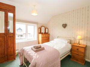 um quarto com uma cama com uma toalha em Primrose Cottage em Wells-next-the-Sea