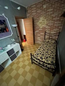 a bedroom with a bed and a brick wall at CASA EVA in Celano