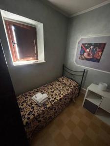 a small bedroom with a bed and a window at CASA EVA in Celano