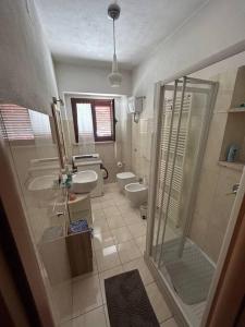 a bathroom with two toilets and a shower and a sink at CASA EVA in Celano